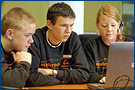 Bild: Zwei Jungen und ein Mädchen vor einem Computer