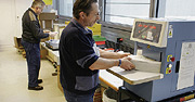 Bild: Ein Papierstapel wird einer Maschine entnommen