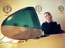 Bild: Frau sitzt hinter einem Computer und surft im Internet