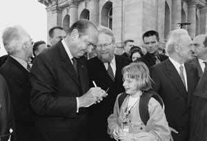 Frankreichs Staatspräsident Jacques Chirac gibt ein Autogramm vor dem Reichstagsgebäude. Neben ihm Bundestagspräsident Wolfgang Thierse