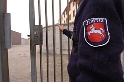 Wärter öffnet Gittertür aus einer Strafvollzugsanstalt