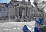 Ein junge Frau steht mit dem Grundgesetz in der Hand vor dem Reichstagsgebäude.