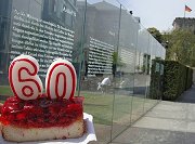 Vor dem Kunstwerk "Grundgesetz 40", einer Gläserwand mit den 19 Grundrechtsartikeln, steht ein Stück Erdbeer-Kuchen mit einer "60"-Kerze darauf.