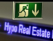 Notausgangsschild vor Schriftzug Hypo Real Estate, Klick vergrößert Bild