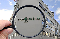 Vergrößerungsglas auf Firmenlogo der Hypo Real Estate, Klick vergrößert Bild