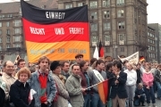 In Dresden stehen am 19.12.1989 Bürger mit Deutschlandfahnen und Transparenten und fordern "Einheit, Recht und Freiheit - Deutschland einig Vaterland".