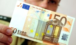 Ein Polizeibeamter hält einen 50 Euro Geldschein in der Hand.