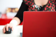 Rot gekleidete Frau am roten Laptop