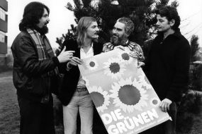 Milan Horacek, Hubert Kleinert, Klaus Hecker und Joschka Fischer halten ein Wahlplakat der Grünen in den Händen.