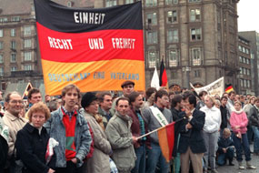 In Dresden stehen am 19.12.1989 Bürger mit Deutschlandfahnen und Transparenten und fordern "Einheit, Recht und Freiheit - Deutschland einig Vaterland".