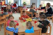 Kinder beim Mittagessen an gedeckten Tischen. - Video ansehen... - Öffnet neues Fenster