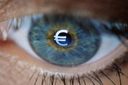 Ein menschliches Auge in Großaufnahme, auf der Pupille das Euro-Zeichen.  - Video ansehen... - Öffnet neues Fenster