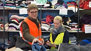 Die sogenannten Scouts Michael Simon und Dorothea von Nordheim überprüfen in einer Kleiderkammer Kleidungsstücke für Flüchtlinge. 