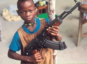 farbiger Junge, der ein Maschinengewehr hält