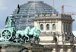 Im Vordergrund sieht man die Quadriga auf dem Brandenburger Tor, im Hintergrund die Kuppel des Reichstagsgebäudes