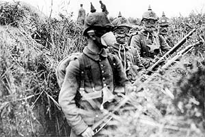 Deutsche Soldaten mit Gas-Schutzmasken im Schützengraben an der Westfront, 1915.