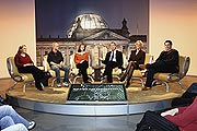 Bild: Sechs Diskussionsteilnehmer sitzen im TV-Studio des Bundestages