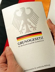 Bild: Hand hält eine Ausgabe des Grundgesetzes