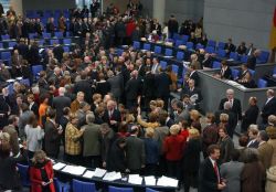 Die Abgeordneten des Deutschen Bundestages haben sich am 13.2.2004 in der Mitte des Plenarsaales in Berlin versammelt, um ihre Stimmkarten abzugeben.