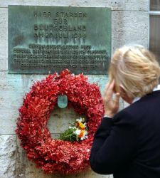 Eine Frau betrachtet die Gedenktafel für die Männer des Hitler-Attentates um Graf von Stauffenberg im Ehrenhof der Gedenkstätte im "Bendlerblock" in Berlin.