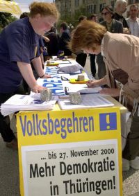 Eine Frau gibt ihre Unterschrift für ein Volksbegehren in Thüringen