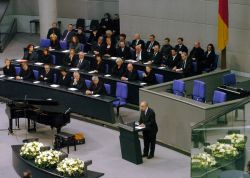 Arno Lustiger steht am Rednerpult im Plenarsaal des Deutschen Bundestages.