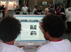 Jugendliche vor einem Bildschirm auf dem die Homepage des Deutschen Bundestages zu sehen ist