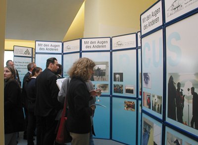 Besucher der Ausstellung betrachten die Stellwände