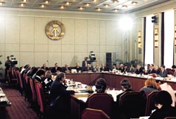 Verhandlungen des Rundes Tisches im Winter 1989/90: An einem rechteckigen Tisch diskutieren Vertreter des alten Systems und der Opposition über die Zukunft der DDR.