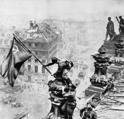 Kurz nach der Eroberung auf dem Dach des Reichstages: Sowjetische Soldaten halten die Rote Fahne (Luftaufnahme).