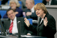 Angela Merkel am Rednerpult und Bundeskanzler Gerhard Schröder in der Regierungsbank