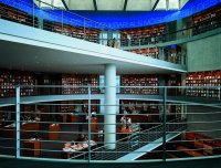 Foto: Rotunde der Bibliothek, auf zwei Ebenen stehen Bücherregale, Benutzer sitzen an Tischen und arbeiten