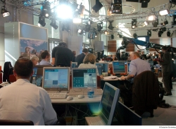 Mehrere Journalisten sitzen an Tischen und bedienen ihre Computer.