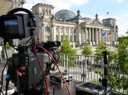 eine Fernsehkamera steht vor dem Westportal des Reichstagsgebäudes