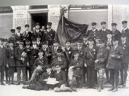 Fotografie einer zeitgenössischen Männergruppe, die sich um die Reichsbannerfahne versammelt hat