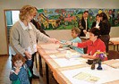 Bild: Mutter mit Kind bekommt Stimmzettel