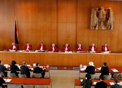 Foto: Gerichtssaal des Bundesverfassungsgerichtes während einer Verhandlung mit Richtern, Klägern und Angeklagten.