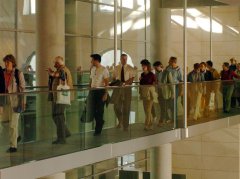 Foto: Besucher laufen an der Rückseite des Plenarsaales im Reichstagsgebäude entlang