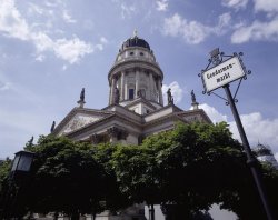 Foto: Deutscher Dom am Gendarmenmarkt, im Vordergrund Bäume und ein Straßenschild