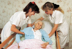 Pflegepersonal hilft einer alten Frau