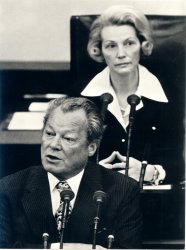 Bundeskanzler Willy Brandt am Rednerpult im Deutschen Bundestag. Im Hintergrund Bundestagspräsidentin Annemarie Renger.