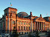 Das Reichstagsgebäude im Abendlicht. Zu sehen ist auf dieser Außenansicht der Westeingang und die Kuppel.