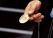 Bild: Hand, die eine Polizeimarke hält