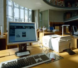 Foto: Ein mit Computer ausgestatteter Arbeitsplatz zur Recherche in der Bibliothek