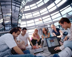 Foto: Jugendliche sitzen mit Laptops in der Kuppel auf dem Reichstagsgebäude, Klick vergrößert Bild