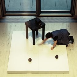 Tisch mit zwei Aggregaten, eine Frau putzt die Ausstellungsfläche