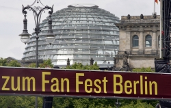 Banner mit der Aufschrift: 'zum Fan Fest Berlin' Im Hintergrung ist die Reichstagskuppel zu sehen.