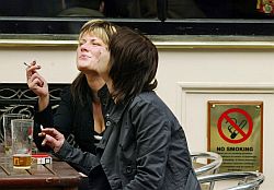 Zwei Frauen rauchen vor einer schottischen Kneipe