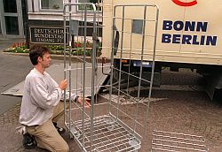 Ein Mitarbeiter eines Umzugsunternehmens baut vor einem Bundestagsgebäude in Bonn ein Gestells zum Transport von Kunstgegenständen zusammen
