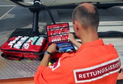 Foto: Über den Rücken eines Rettungsassistenten, der seine Ausrüstung überprüft, Klick vergrößert Bild